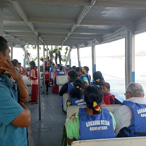 Guests in life jackets seated inside the shaded boat cabin